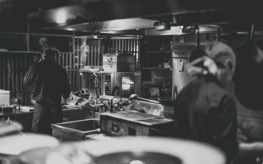 Professional chefs cooking in a commercial kitchen, showcasing restaurant food preparation and teamwork.