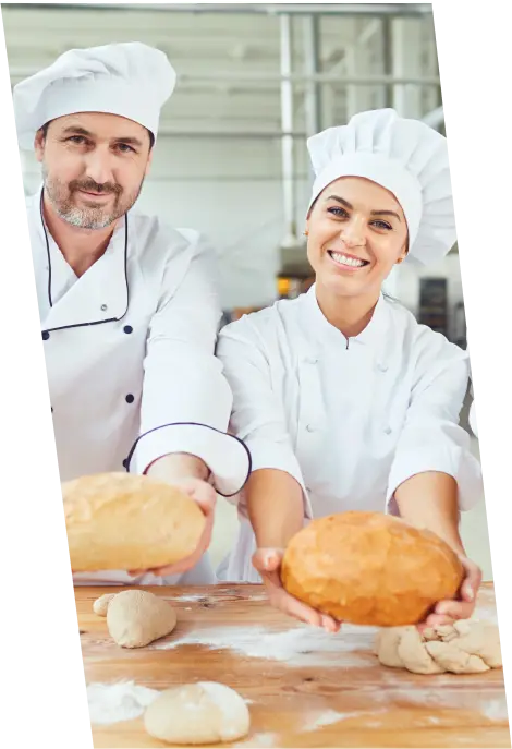 A young male and female chef enthusiastically baking with flour, honing their skills and preparing for new career opportunities in the culinary industry.